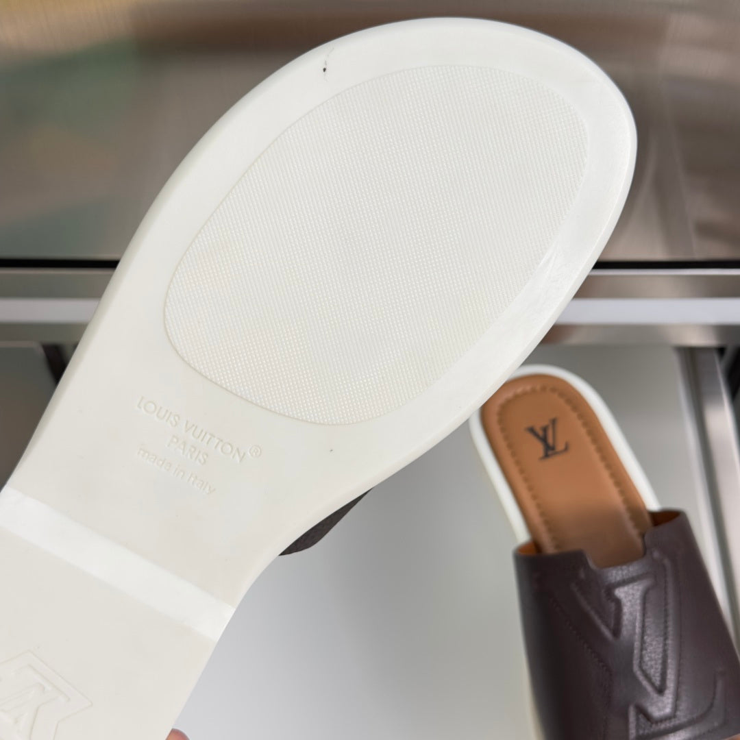 White outsole of dark brown slide sandal with Louis Vuitton branding