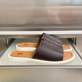 Dark brown leather slide sandals with white sole and Louis Vuitton monogram strap