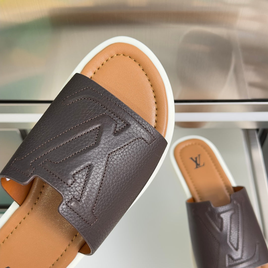 Dark brown leather slide sandal with embossed arrow-like detail and Louis Vuitton logo