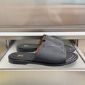 Gray leather slide sandals with wide V-shaped straps and gold LV logo
