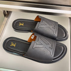 Gray leather slide sandals with double wide strap and gold LV logo detailing