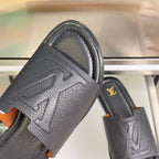 Gray leather slide sandals with embossed chevron strap and gold LV logo on strap