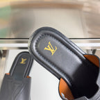 Gray leather slide sandal with gold LV logo on footbed and tan edge accents