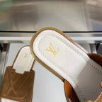 Suede slide sandal heel strap close-up with LV logo on white lining.