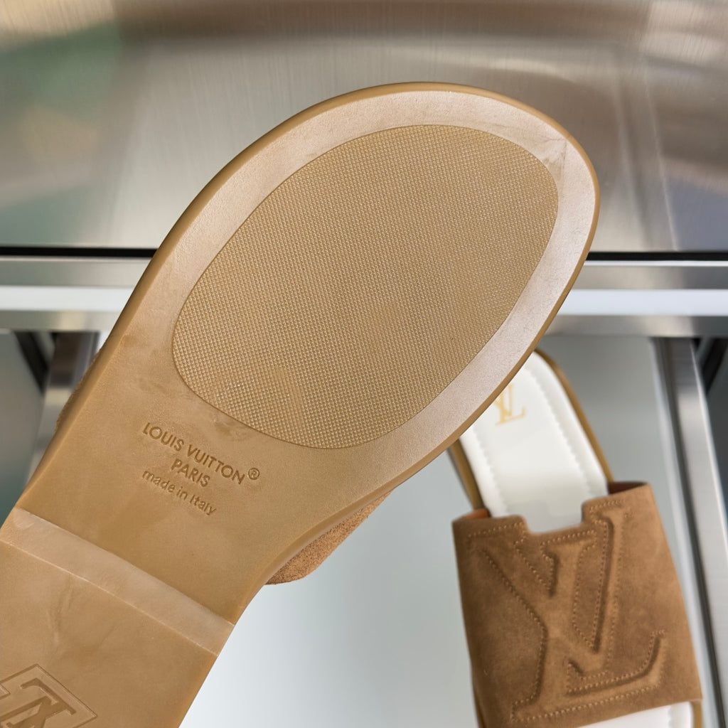 Louis Vuitton suede slide sandal outsole with embossed text and traction tread.