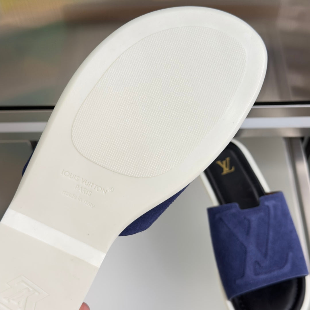 White outsole of blue suede Louis Vuitton slide sandal with traction tread