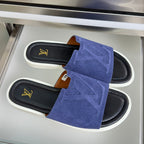 Pair of blue suede slide sandals with gold LV logo on black footbeds, white soles
