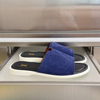 Blue suede slide sandals with gold LV logo on black strap, white rubber sole