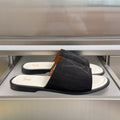 Black suede slide sandals with gold LV logo on the footbed