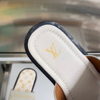 Louis Vuitton sandal detail: white strap with gold LV logo, black edge trim