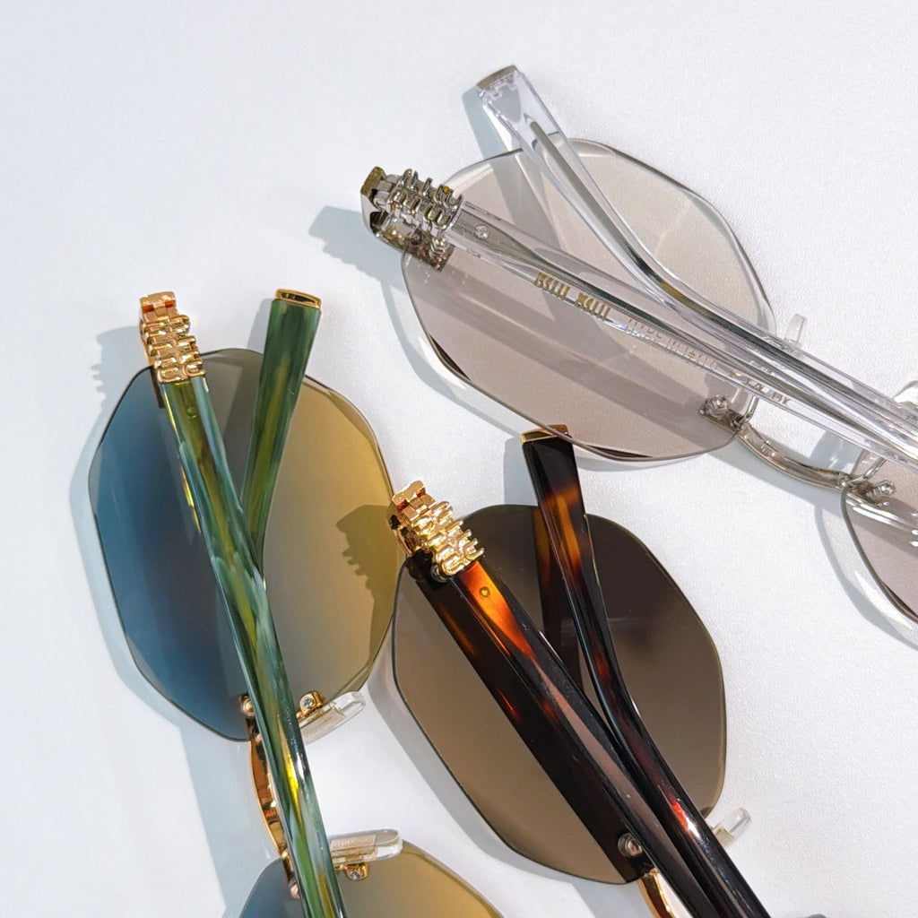 Assorted sunglasses close-up with gold frames and blue and brown mirrored lenses