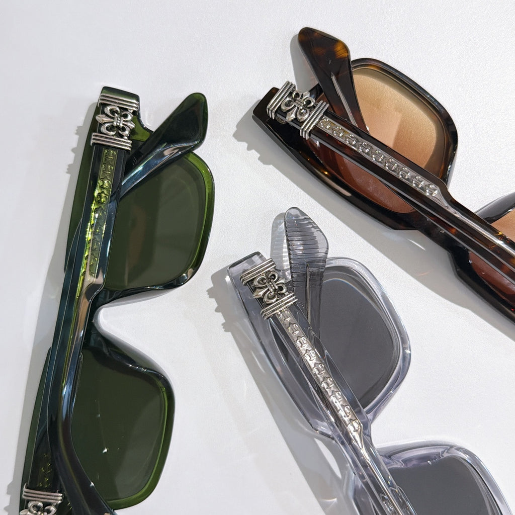 Overlapping sunglasses with green, tortoiseshell, and clear frames and tinted lenses