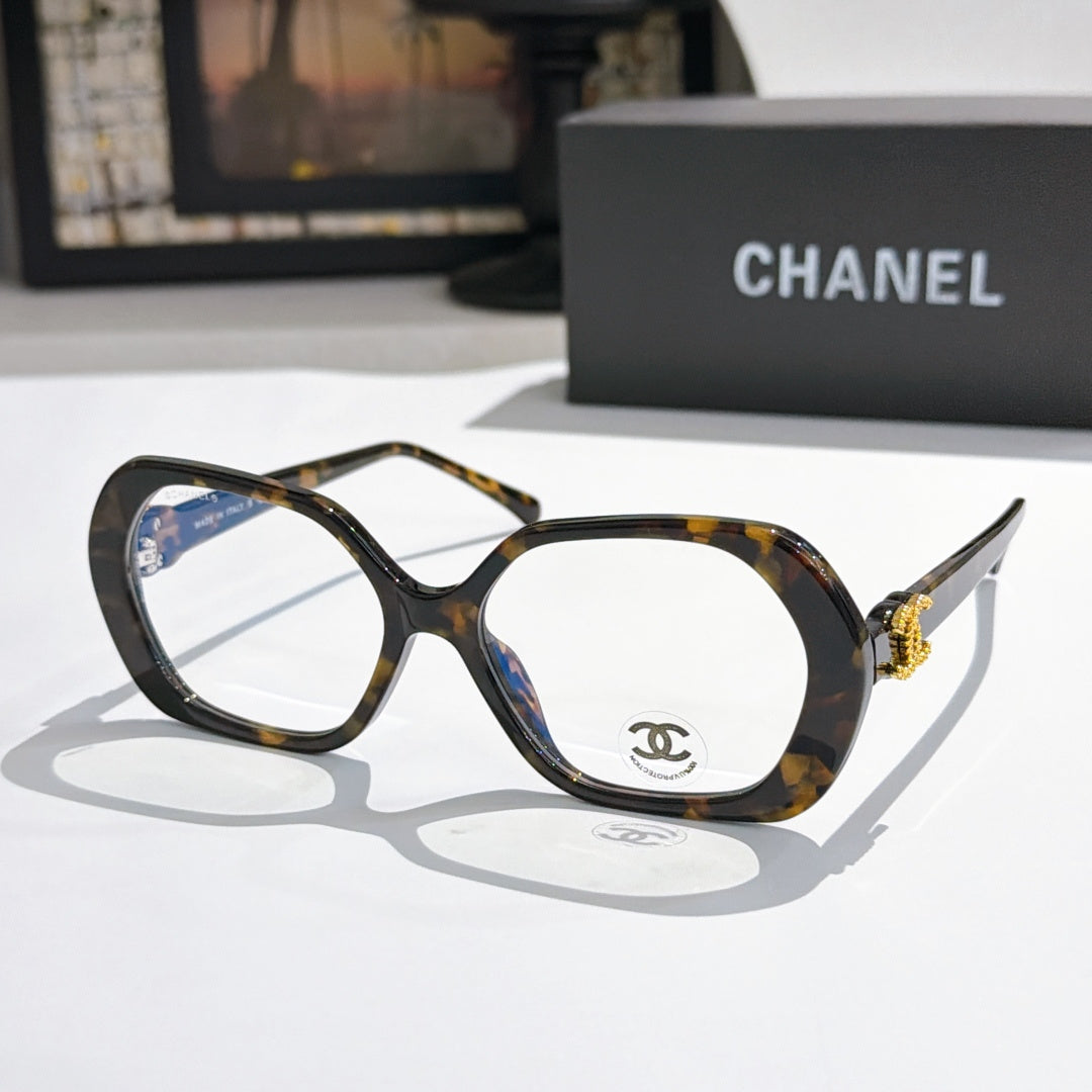 Chanel eyeglasses, dark tortoiseshell frames with gold-tone temple logo and clear lenses