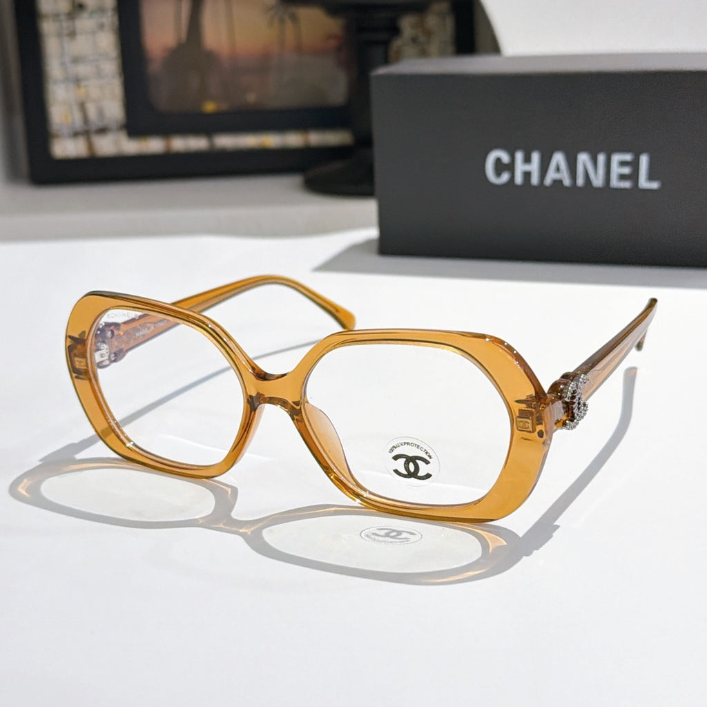Chanel eyeglasses, amber/gold rounded frames with gold-tone temple logo and clear lenses