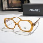 Chanel eyeglasses, amber/gold rounded frames with gold-tone temple logo and clear lenses