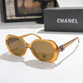Chanel sunglasses, amber-brown frames, brown tinted lenses, gold logo detail.