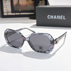 Chanel sunglasses, dark gray frames with patterned temples, dark tinted lenses.
