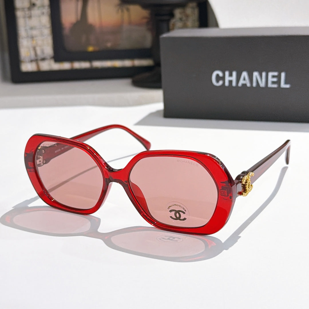 Chanel sunglasses, red frames, red tinted lenses, gold logo detail.