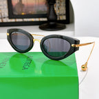 Bottega Veneta glasses with dark frames and gray tinted lenses, gold-tone side accents