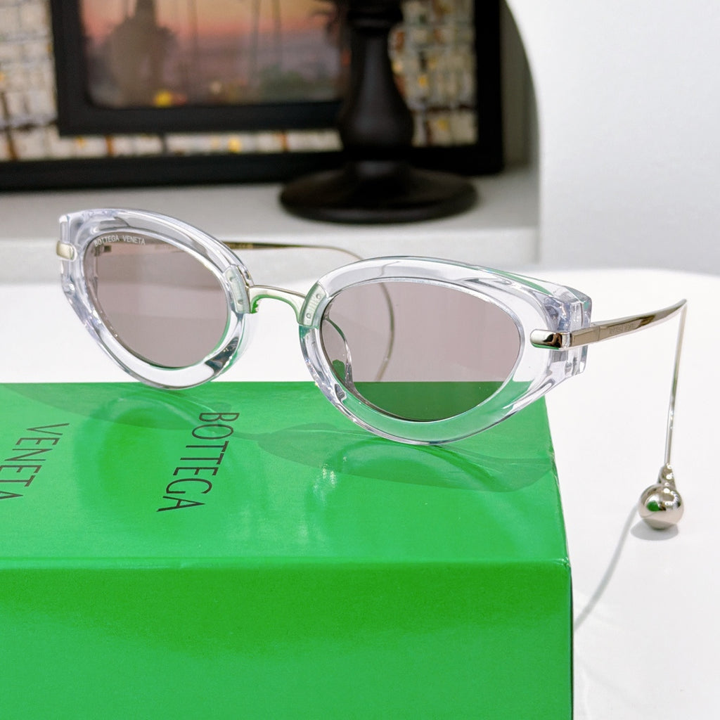 Bottega Veneta glasses with clear frames and light gray tinted lenses, gold-tone hardware