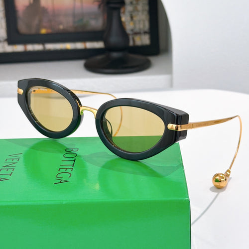 Bottega Veneta glasses with dark frames and amber tinted lenses, gold-tone accents