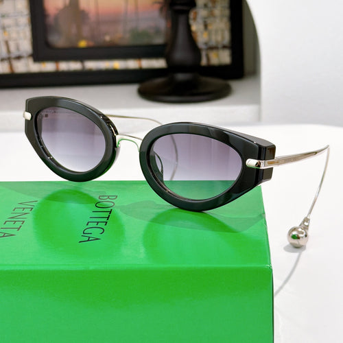 Bottega Veneta glasses with dark frames and light purple tinted lenses, gold-tone hinge