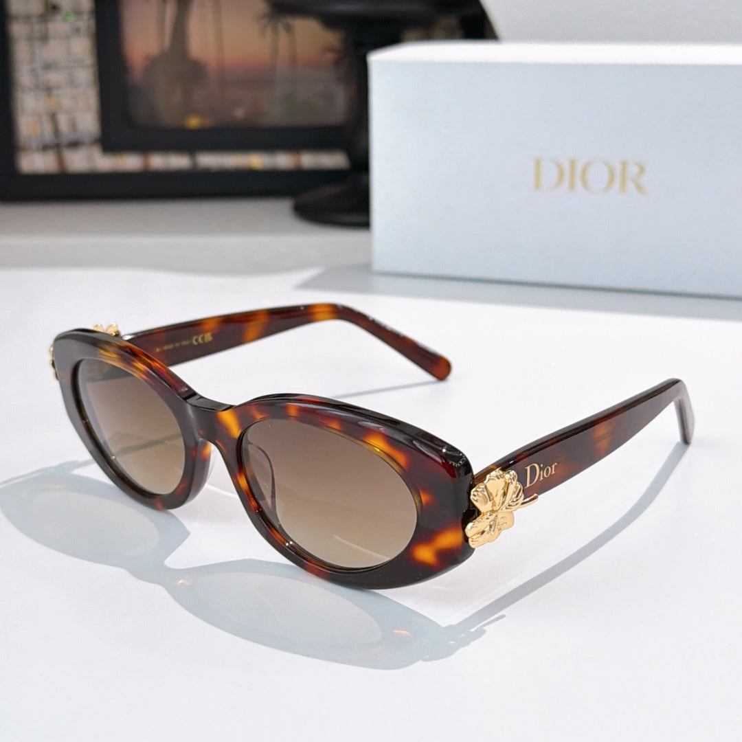 Tortoise oval sunglasses with beige lenses and gold logo detail at temple
