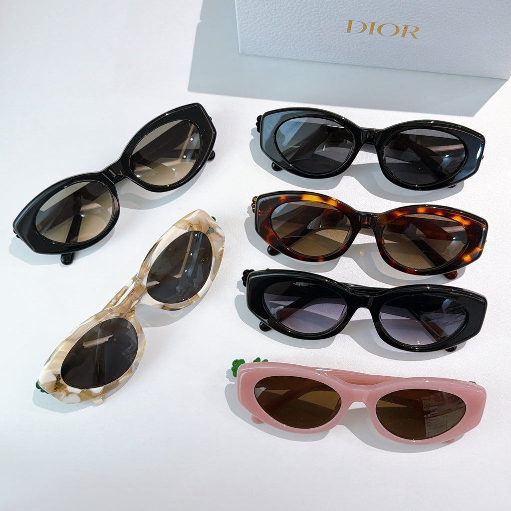 Assorted sunglasses laid out: black, tortoise, cream, and pink frames with lenses