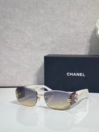 White-accent sunglasses with clear-to-light lenses and side logo detail, metal temples