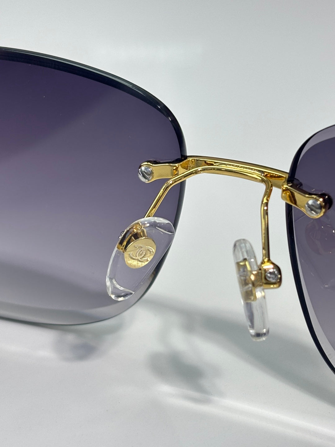 Close-up of gold sunglasses frame with dark lenses and metal hinge detail