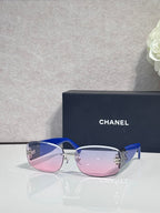 Blue-accent sunglasses with pink-tinted lenses and side logo detail, metal temples