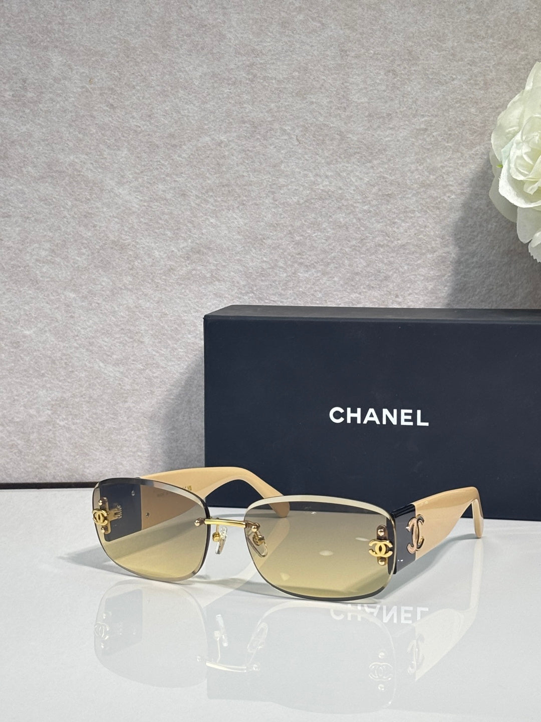 Gold-framed sunglasses with yellow-tinted lenses and side logo detail, metal temples