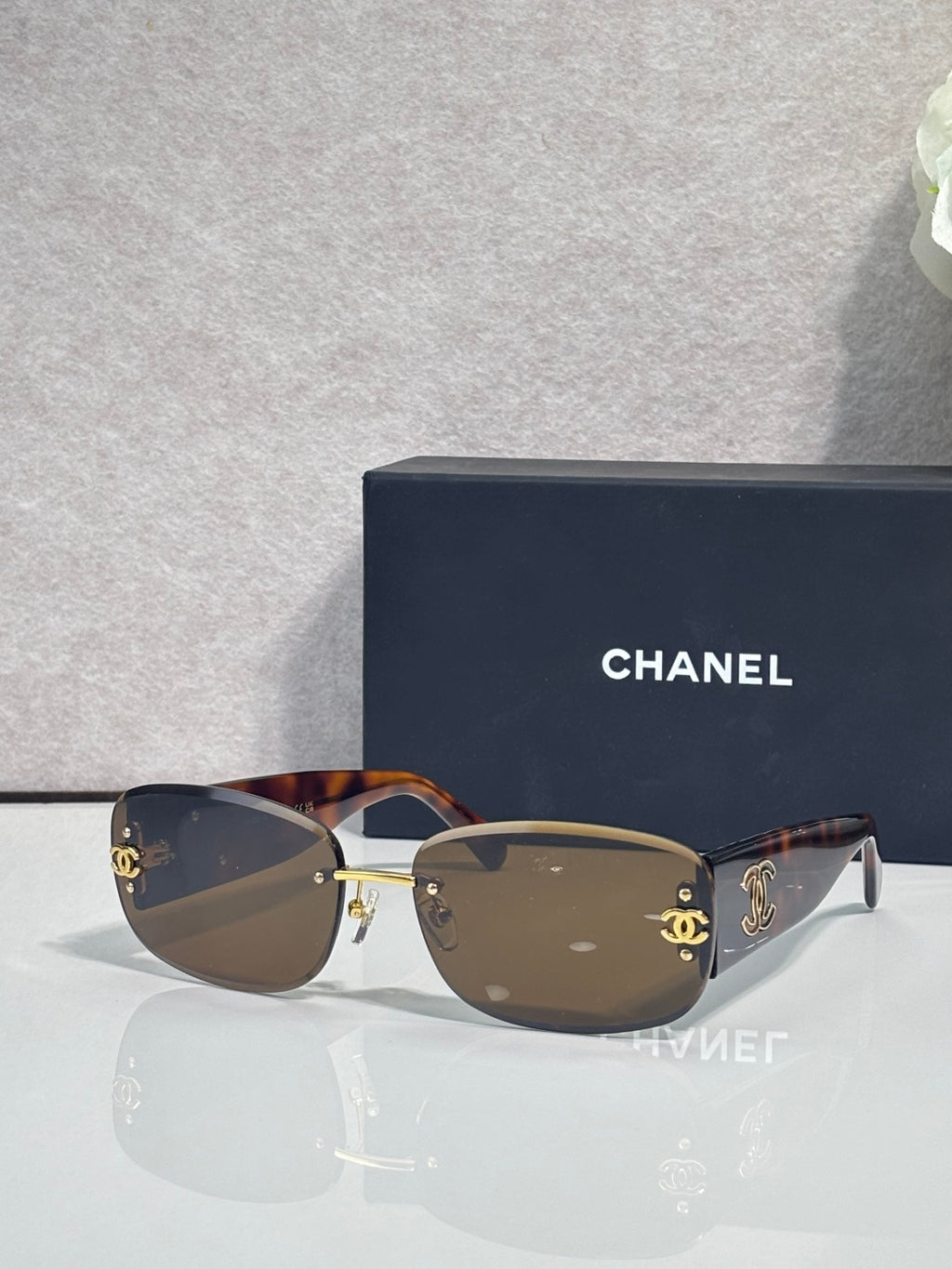 Tortoise-toned sunglasses with dark lenses and side logo detail, metal temples