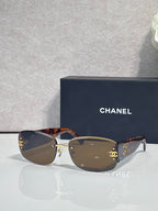 Tortoise-toned sunglasses with dark lenses and side logo detail, metal temples
