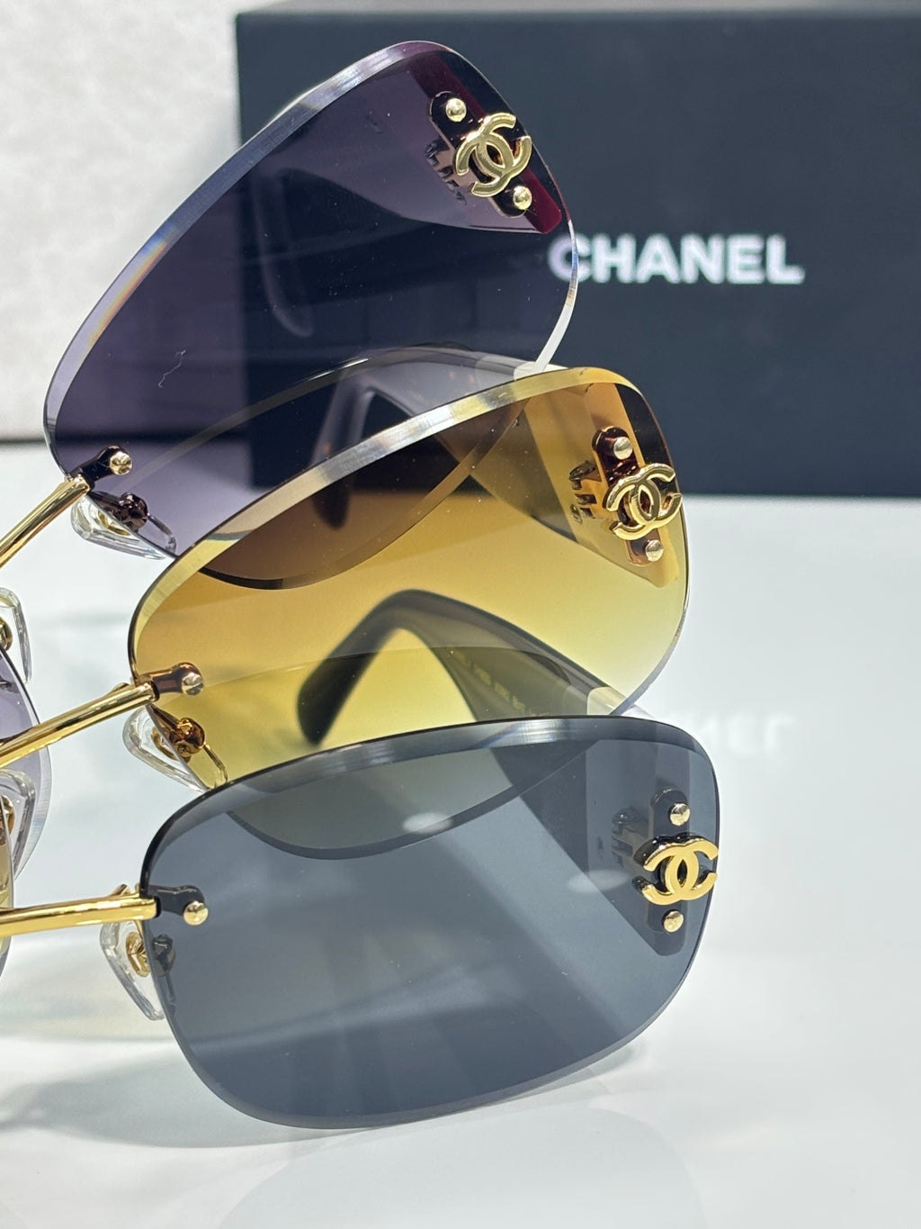 Stacked sunglasses with dark upper lens and gold mirror lens, logo temples
