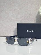 Gold-framed sunglasses with dark lenses and side logo detail, slim metal temples