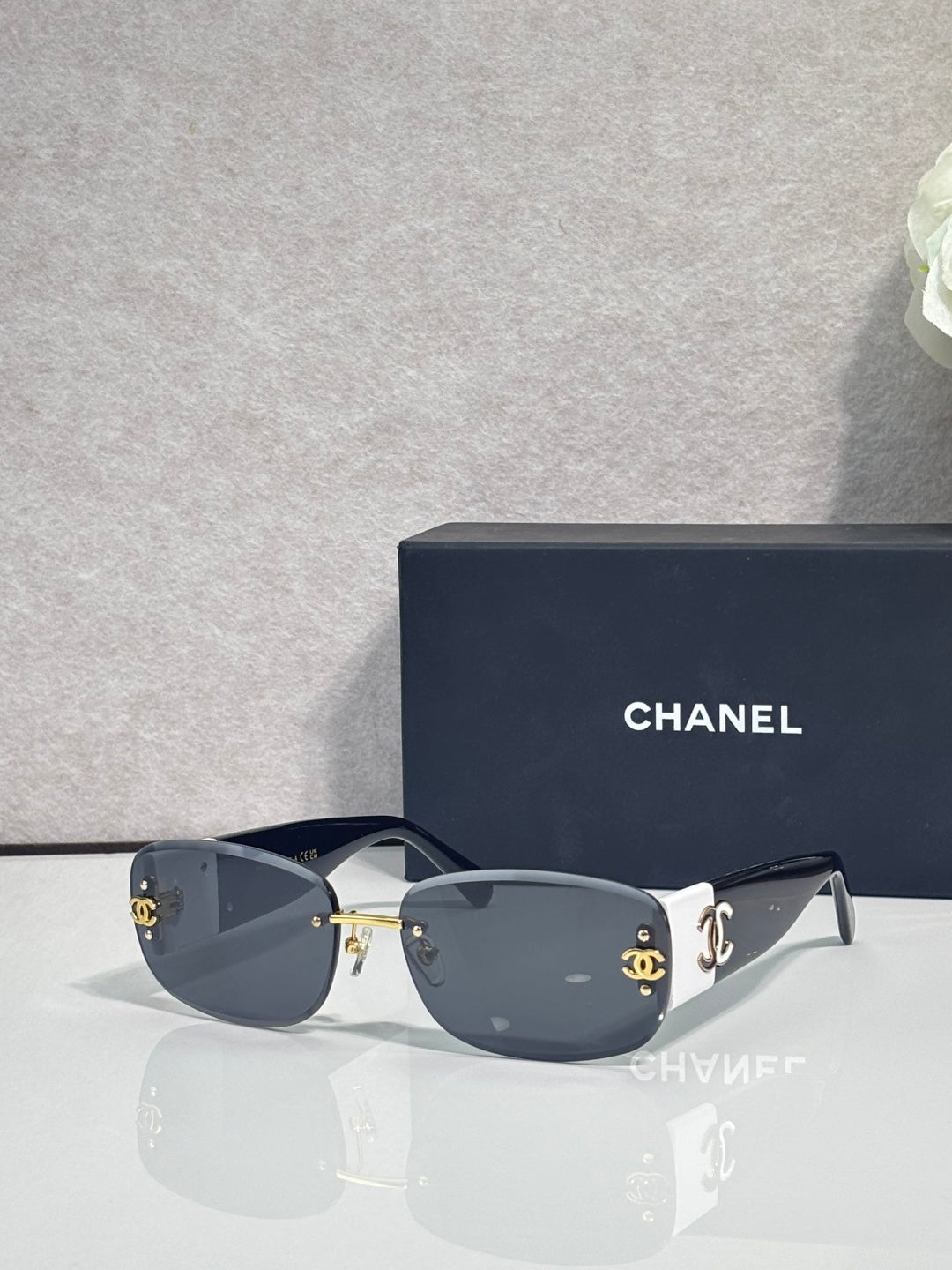 Gold-framed sunglasses with dark lenses and side logo detail, slim metal temples