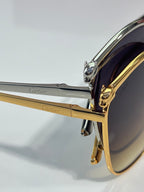 Cartier sunglasses close-up: chrome-and-gold temple with hinge detail