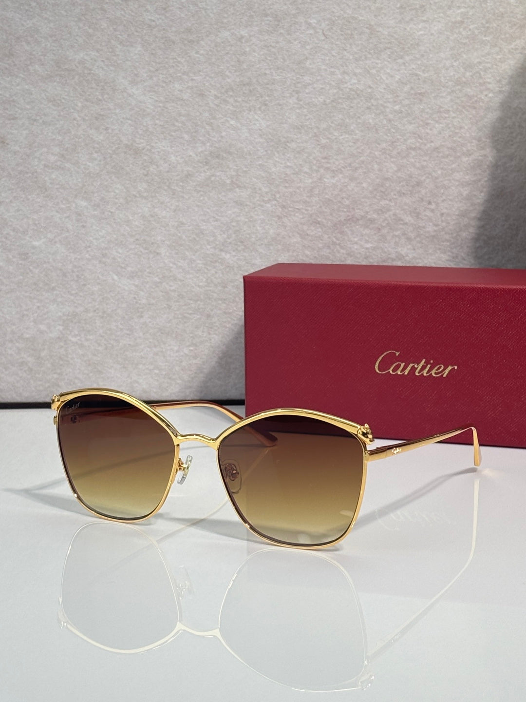 Cartier sunglasses with gold round frames and amber gradient lenses