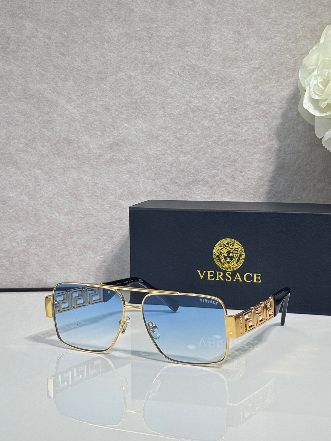 Versace sunglasses with gold frame and light blue lenses, Greek-key temple accents