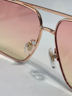 Versace sunglasses close-up of rose-gold frame and clear lens edge