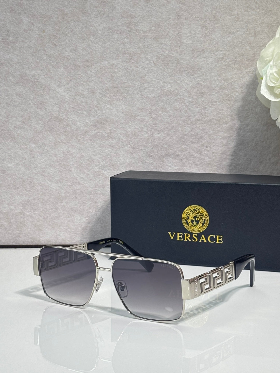 Versace sunglasses with silver frame and dark lenses, geometric temple detail