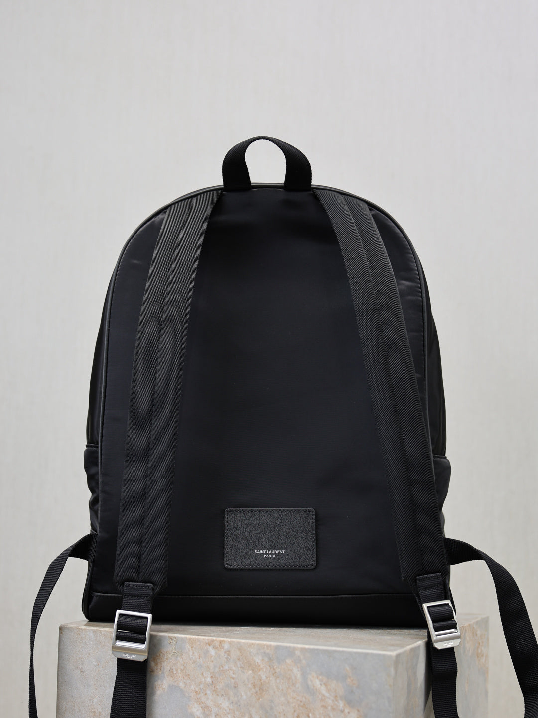 YSL black backpack back view with adjustable shoulder straps and logo patch