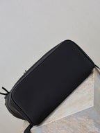YSL black zip pouch-style bag with curved top and zipper closure, side view