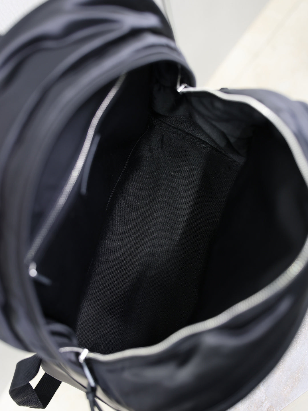 YSL black backpack interior view with fabric lining and side zipper opening