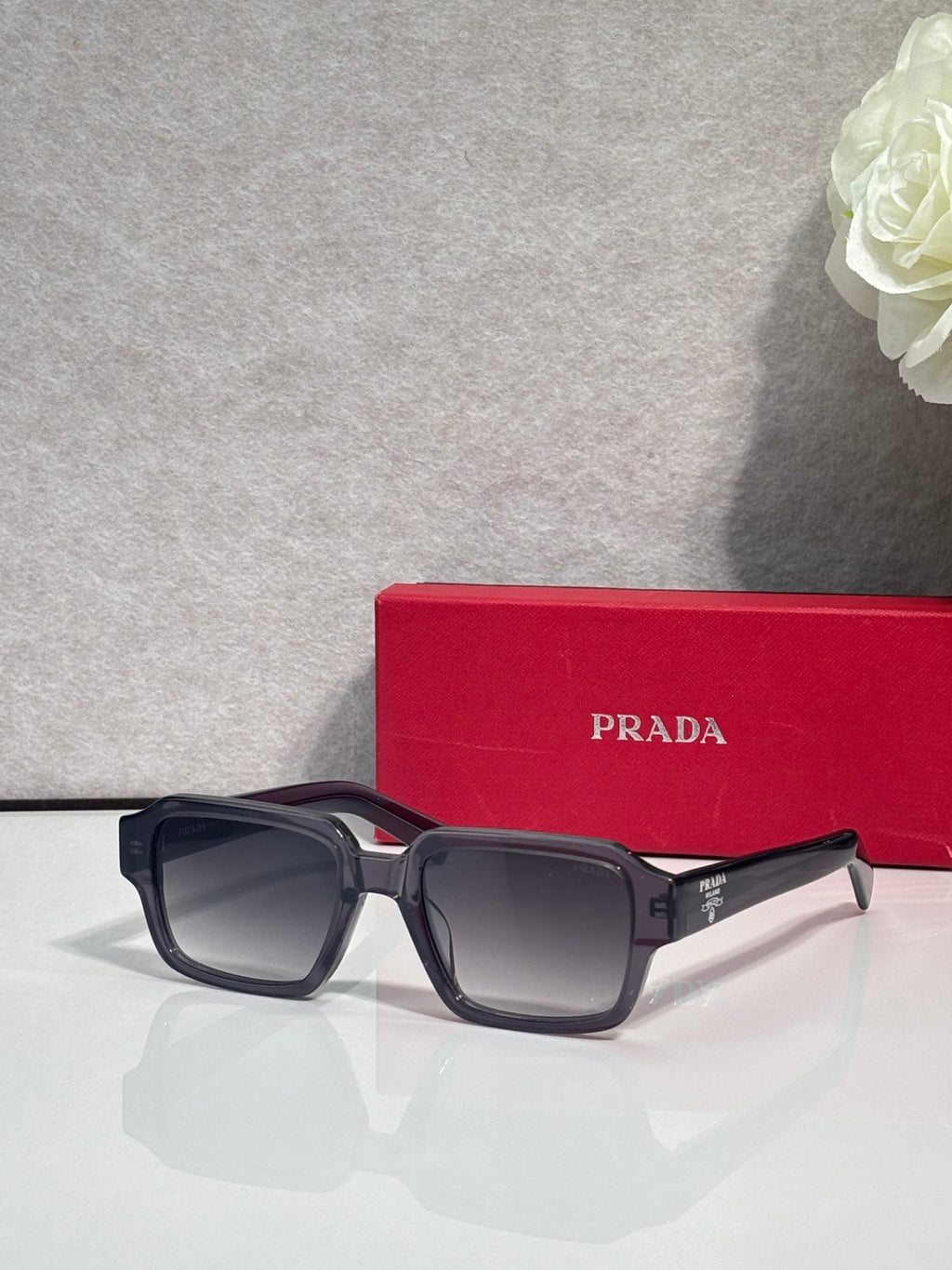 Black square sunglasses with gradient dark lenses on red case