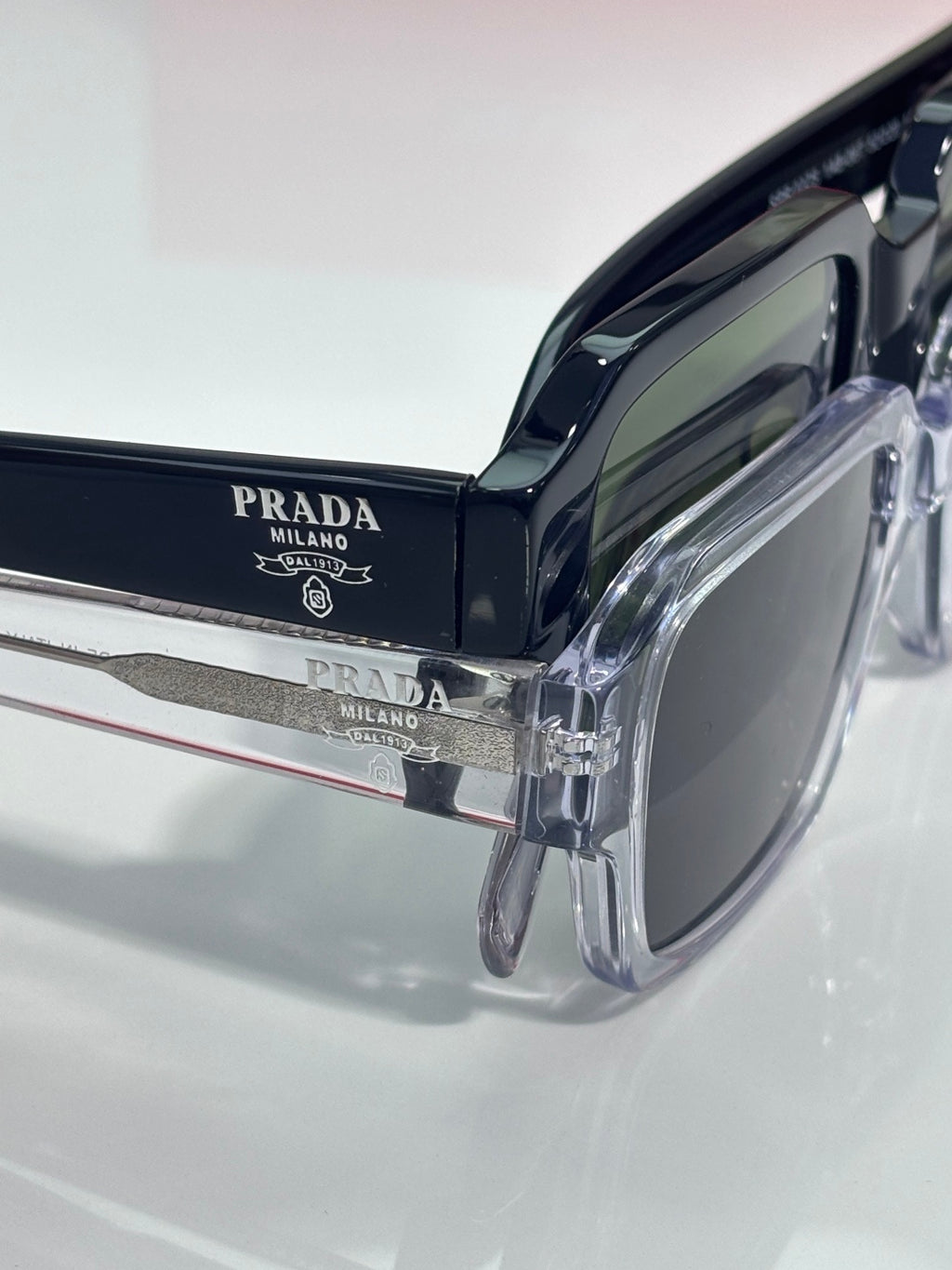 Black sunglasses temple with Prada Milano logo and dark lens