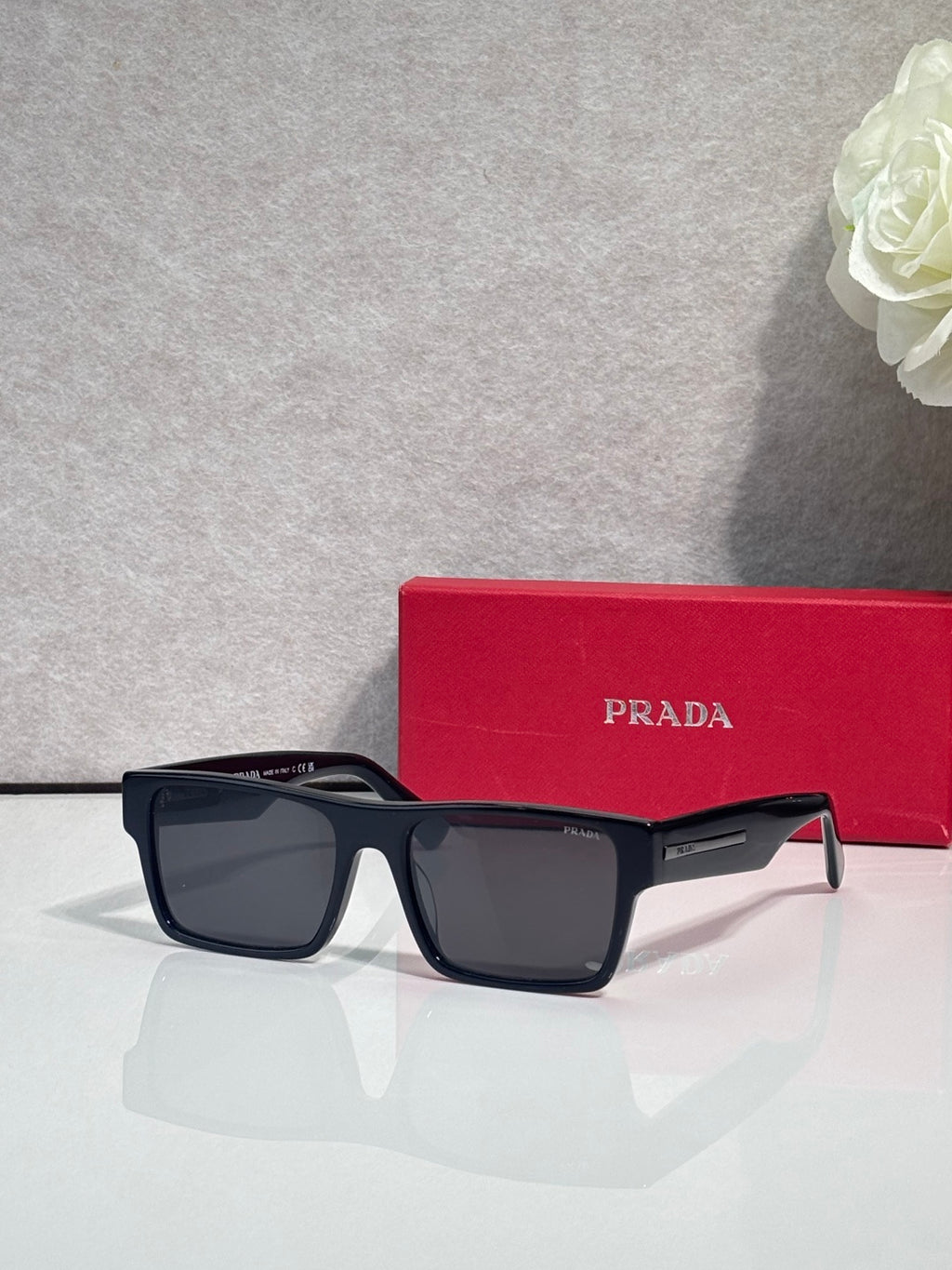 Prada square sunglasses with dark frames and clear-to-brown gradient lenses