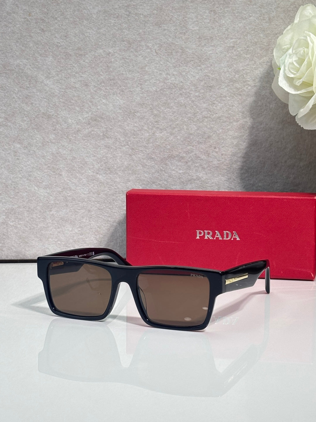 Prada square sunglasses with dark frames and amber-brown gradient lenses