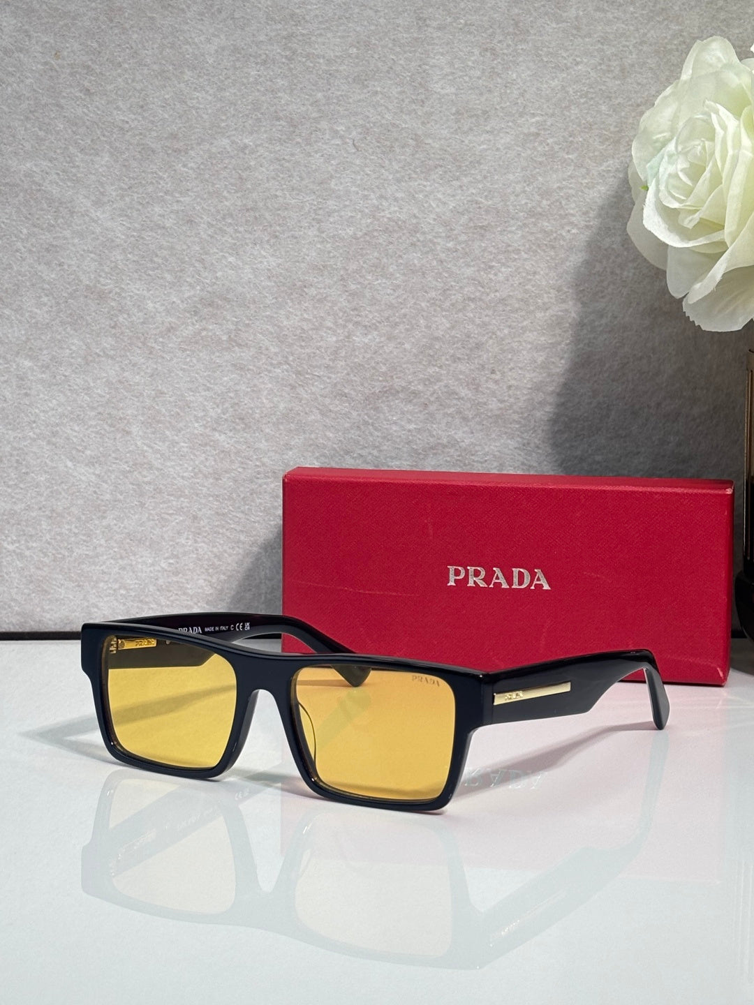 Prada square sunglasses with dark frames and yellow lenses